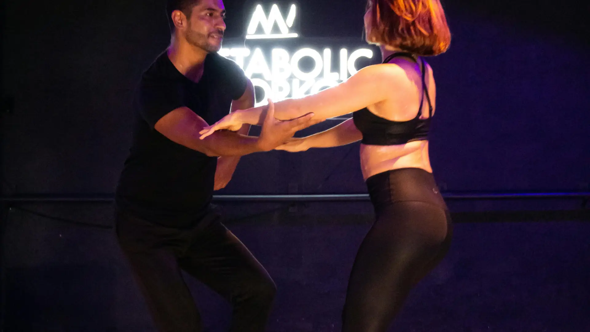 Latina dance instructor teaching a private bachata lesson with a warm, confident expression